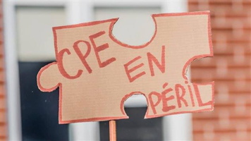 Photo d'une petite pancarte de manif en forme de pièce de casse-tête : CPE en péril.