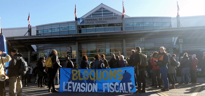 Photo : une foule devant le Terminal de croisière / Cruise Terminal, avec une banderole bleu : Bloquons l'évasion fiscale.
