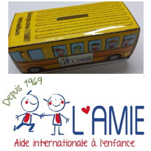 Photo de la boîte de collecte qui a la forme d'un sympathique autobus jaune avec des enfants aux fenêtres. Logo de L'AMIE : petit garcon et petite fille allumettes se tenant par la main, souriant. Depuis 1969.