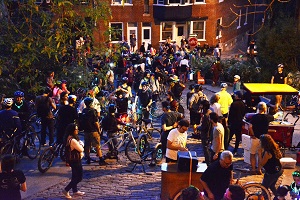 Photo d'une édition passée : une centaine de cyclistes et de piétons sur la côte Badelard qui fêtent. Kiosques et hotdogs aussi.