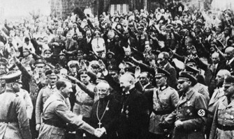 Photo ancienne authentique : dans une foule dense de gens faisant le salut hitlérien, Hitler serre la main de Ludwig Müller, un membre du clergé —d'ailleurs vêtu en soutane catholique— et membre du parti nazi.