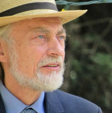Photo de Robert, un peu de profile : courte barbe blanche, veston bleu, chapeau de paille. Regard au loin, yeux bleus. Il a environ 60 ans sur la photo, tirée de Facebook.