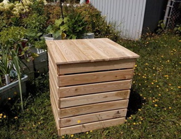 Photo : boîte en bois blancs sur du gazon près d'un jardin de maison.