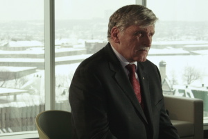 Photo : M. Dallaire, assis calmement dans un gratte-ciel, l'air pensif.