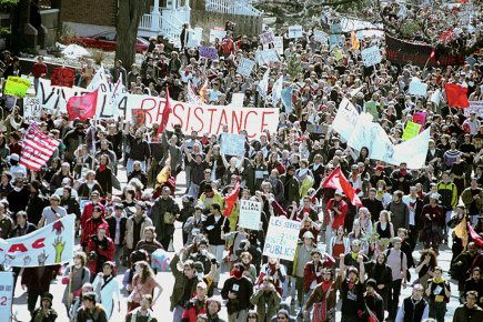 Photo d'une foule, prenant toute l'espace de la rue. Une banderole est lisible: Vive la résistance !