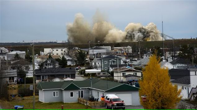 Photo de Radio-Canada où on voit une explosion gigantesque pas très loin de la ville, soit plusieurs maisons. L'article source de la photo est lié.