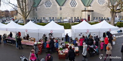 Photo de 2017 : journée ensoleillée d'hiver ; côté de la grande église ; nombreuses tentes pavillons blanches ; des gens visitent divers kiosques.