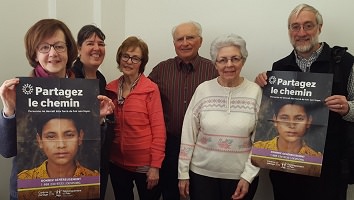 Photo de six bénévoles de Développement et Paix à Charlesbourg tenant deux affiches de la campagne « Partagez le chemin ...». Ils/elles ont 40 ans et plus.