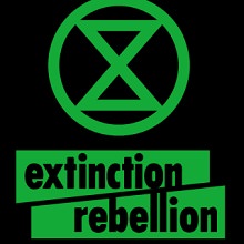 Affichette sur fond noir : un x vert dans un cercle vert « extinction rebellion »