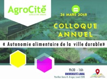 Affiche : photo d'une zone avec beaucoup d'arbustes et de cours d'eau, mais avec des bâtiments habités sur le long. Deux hexagones superposés : un jaune, un rose-violet. « Autonomie alimentaire de la ville durable ».